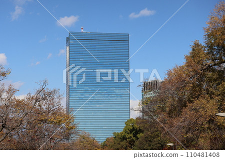 藍天、雲彩和樹林外可見摩天大樓的城市景觀 110481408