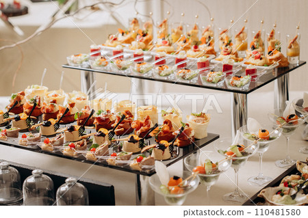 Assortment of delicious snacks on the open buffet festive table in restaurant. Catering plate 110481580