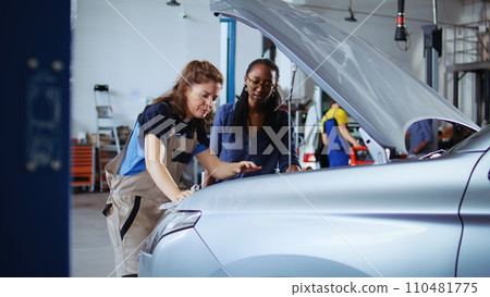 Qualified repairman in garage finishing fixing car for customer, removing remaining oil leaks inside vehicle. Expert does parts cleaning on african american client automobile in repair shop Qualified repairman in garage finishing fixing car for customer, removing remaining oil leaks inside vehicle. Expert does parts cleaning on african american client automobile in repair shop 110481775