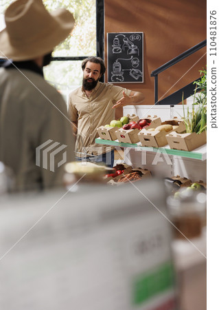 Male customer gestures curiously while holding a basket in an environmentally friendly grocery store. Caucasian man looking around supermarket for freshly harvested organic produce. 110481876