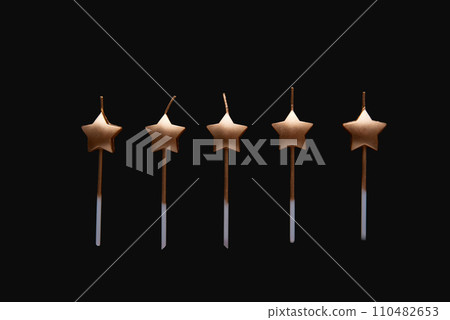 Holydays star shaped candles isolated on a black background. Merry Christmas and Happy New Year. 110482653