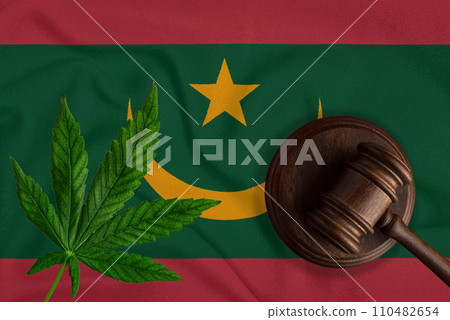 Judge wooden gavel, fresh hemp leaf against the background of Mauritania flag. Illegal sale and distribution of marijuana 110482654