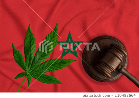 Judicial wooden gavel, fresh hemp leaf and Morocco flag. Illegal sale and distribution of marijuana Judicial wooden gavel, fresh hemp leaf and Morocco flag. Illegal sale and distribution of marijuana 110482664