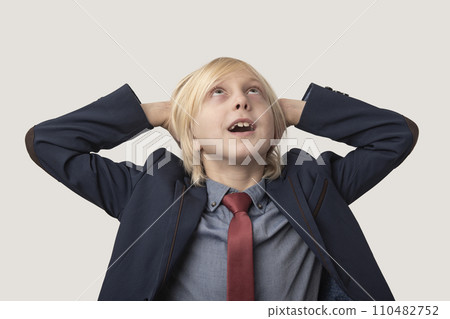 Frustrated young businessman with hands behind head and looking up 110482752