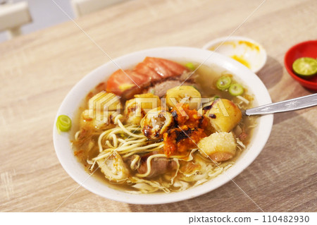 A steaming bowl of Soto Mie Bogor, a traditional Indonesian noodle soup 110482930