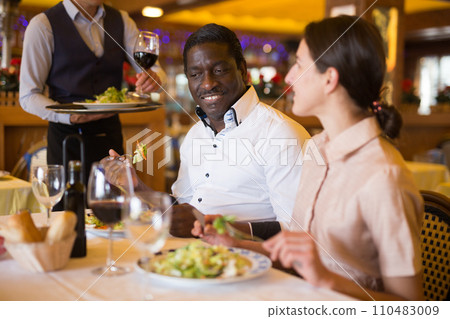 Cheerful man and woman dating in restaurant Cheerful man and woman dating in restaurant 110483009