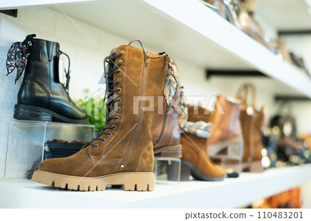 Demi-season suede and leather womens boots on shelves in store Demi-season suede and leather womens boots on shelves in store 110483201