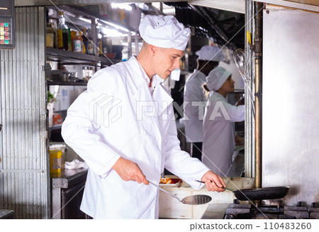 portrait of happy male cook cooking dishes in restaurante portrait of happy male cook cooking dishes in restaurante 110483260