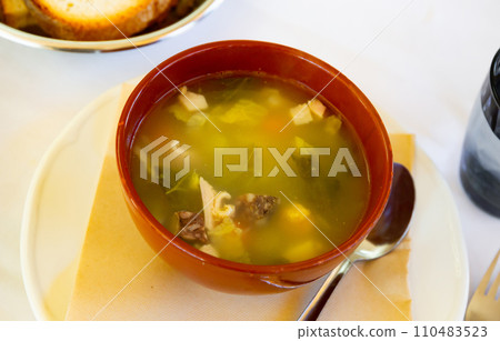 Escudella barrejada soup is poured in deep clay bowl - cooked according to old Catalan recipe Escudella barrejada soup is poured in deep clay bowl - cooked according to old Catalan recipe 110483523
