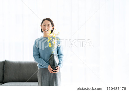 一位 30 多歲的女士用鮮花裝飾她的房間 110485476