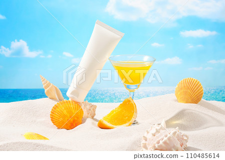 On the white sand surface, a cosmetic tube, a cocktail glass, snail shells and watered oranges are displayed. Blue sky background with white clouds. 110485614