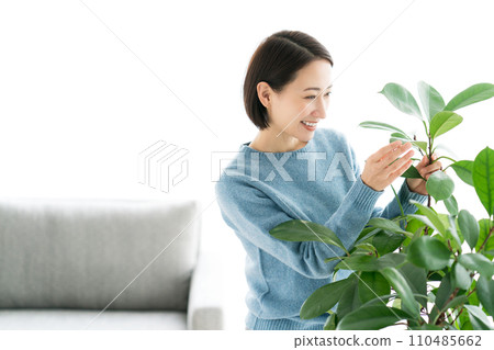 一位 30 多歲的女性正在照顧室內植物 110485662