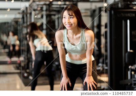 A woman taking a breather at the gym A woman taking a breather at the gym 110485737