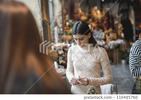 Engaging in a masterclass, a young lady creates Christmas decorations. 110485760