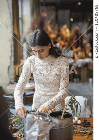 The crafted Christmas wreath is ready for sale, positioned on the flower shop counter. 110485769