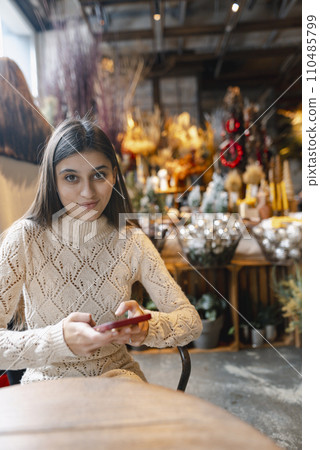 A beautiful woman explores the decor store with her phone in hand. A beautiful woman explores the decor store with her phone in hand. 110485799