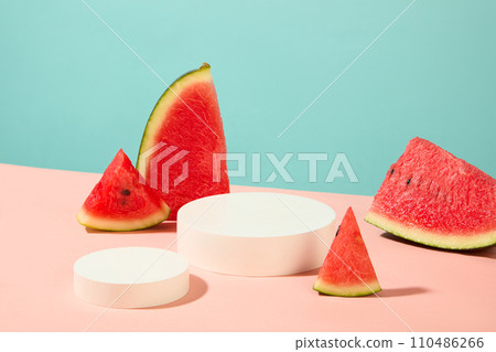 White podiums in round shaped arranged on the surface with slices of watermelon. Mock-up for exhibitions or presentation of cosmetic products or packaging White podiums in round shaped arranged on the surface with slices of watermelon. Mock-up for exhibitions or presentation of cosmetic products or packaging 110486266