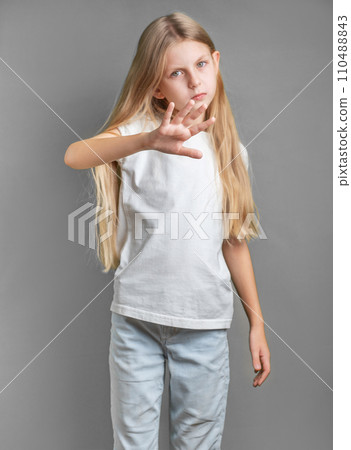 A little girl showing a sign of protest or refusal with her hand. 110488843