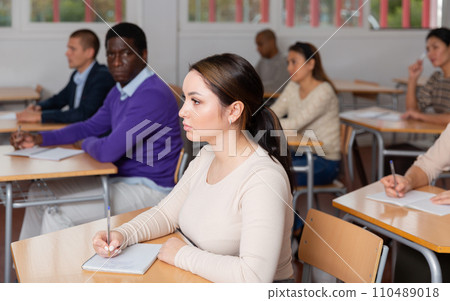 Young woman studying with colleagues at classroom Young woman studying with colleagues at classroom 110489018