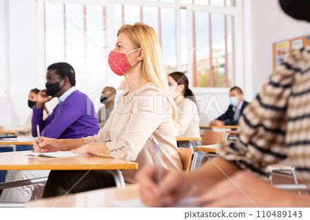 Woman in face mask studying with colleagues 110489143