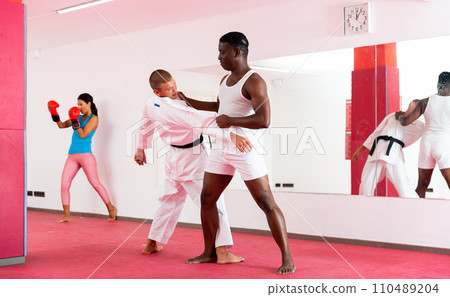 Men perform strength techniques and grabs at self-defense training in sports club 110489204
