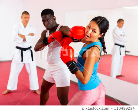 Boxing training between man and woman in sports club Boxing training between man and woman in sports club 110489284