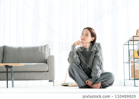 Photo of a woman relaxing in her room 110489920