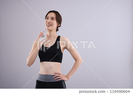 Woman hydrating in sportswear 110490604