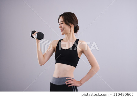 Woman in sportswear with dumbbells Woman in sportswear with dumbbells 110490605