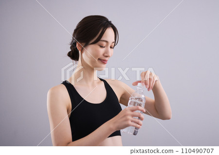 Woman hydrating in sportswear 110490707