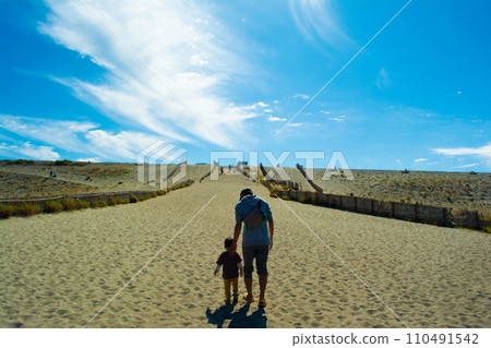 Nakatajima Sand Dunes, back view of walking parent and child and blue sky 110491542