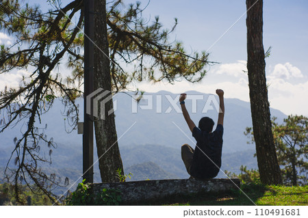 landscape and travel concept with solo freelancer man sit on wooden and use tablet work from outdoor with layer of mountain background landscape and travel concept with solo freelancer man sit on wooden and use tablet work from outdoor with layer of mountain background 110491681