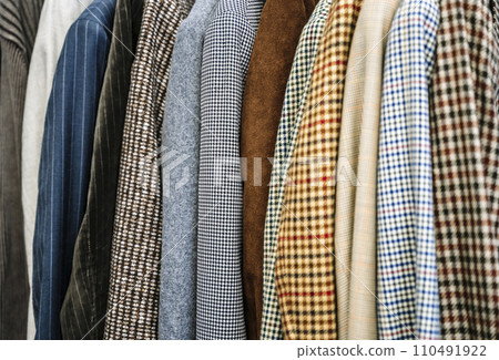 Second hand vintage clothes in a store on sale. Fashionable European used retro jeans, t-shirts, dresses, pants and accessories. Recycling and life extension for clothes concept. 110491922
