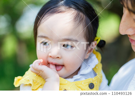 小女孩被父親抱著吸吮大拇指 110493126