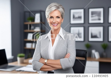Close-up portrait of smiling senior businesswoman standing in the office while looking at camera. Close-up portrait of smiling senior businesswoman standing in the office while looking at camera. 110493405