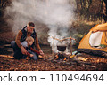 Man and boy tourists autumn time leisure, vacation hiking or traveling touristic activity. Family camping, father and little son relax in forest camp. 110494694