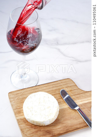 Prepare camembert cheese and pour red wine into a wine glass Prepare camembert cheese and pour red wine into a wine glass 110495061