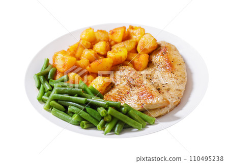 Plate of grilled turkey chops, baked potatoes and green beans on white background 110495238