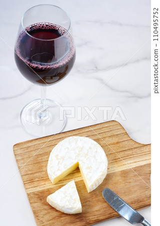 Red wine and camembert cheese poured into a wine glass 110495752