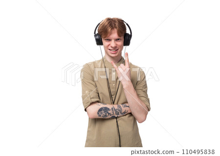 young handsome redhead man in glasses and shirt enjoying playlist in headphones young handsome redhead man in glasses and shirt enjoying playlist in headphones 110495838