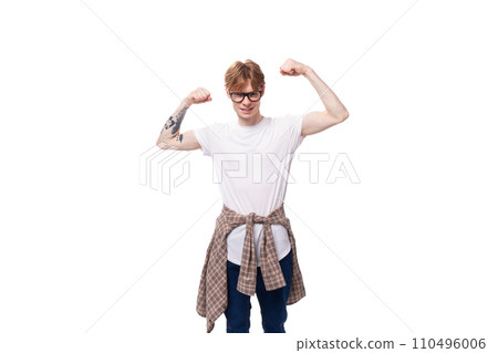 caucasian young man with red hair in a t-shirt and shirt shows strength and muscles caucasian young man with red hair in a t-shirt and shirt shows strength and muscles 110496006