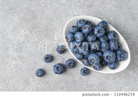 Fresh blueberries in a small round bowl on gray concrete background with copy space 110496259