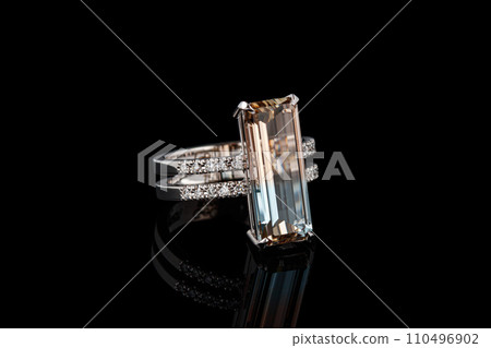 beautiful gold ring with topaz gemstones on a black background 110496902