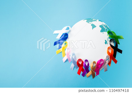 World cancer day concept with world map and many colorful awareness ribbon.Healthcare and medical concept. Copy space World cancer day concept with world map and many colorful awareness ribbon.Healthcare and medical concept. Copy space 110497418