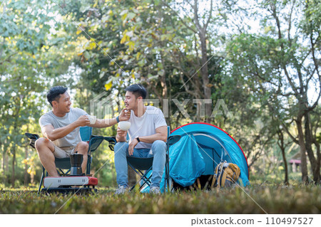 Male gay couple asian traveling with tent camping outdoor and various adventure lifestyle hiking active summer vacation. drinking coffee and talking together 110497527