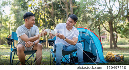 Male gay couple asian traveling with tent camping outdoor and various adventure lifestyle hiking active summer vacation. drinking coffee and talking together Male gay couple asian traveling with tent camping outdoor and various adventure lifestyle hiking active summer vacation. drinking coffee and talking together 110497538