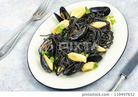 Mussels and black pasta. 110497632