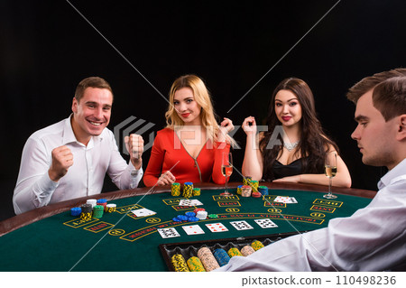 Friends enjoying a gambling night. The dealer deals the cards Friends enjoying a gambling night. The dealer deals the cards 110498236