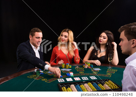 Friends enjoying a gambling night. The dealer deals the cards Friends enjoying a gambling night. The dealer deals the cards 110498248
