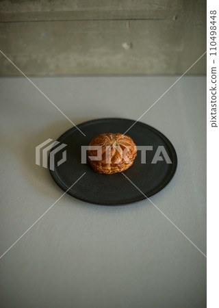 Pithivier, a Western confectionery on a black plate Pithivier, a Western confectionery on a black plate 110498448